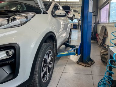 Benzin istasyonunda asansördeki beyaz araba..