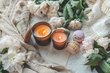 Sıcak bir evde yanan iki mum, beyaz şakayıklar ve badem kurabiyeleri..