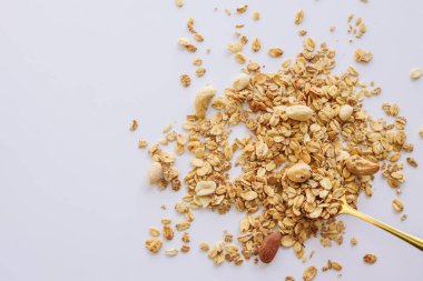 Beyaz arka planda izole kaşık üzerinde Granola, kopya alanı. Sağlıklı atıştırmalık veya kahvaltı konsepti - tahıl ve fındık ile ev yapımı granola.
