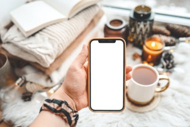 Noel atmosferinde metin için izole edilmiş bir yere sahip telefon ellerinde.