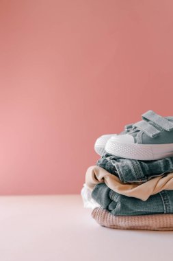 Bebek ayakkabılı bebek kıyafetleri yığını. Reklamcılık, tarz ve moda.