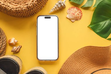 Yaz aksesuarlarının arka planında izole bir ekran olan telefon, reklam için bir yer.