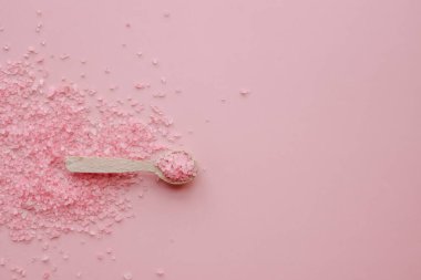 Pembe arka planda aromatik pembe Himalaya deniz tuzu. Ev yapımı bitkisel banyo tuzu. Rahatlamak için cilt bakımı güzellik banyosu kozmetik ürünleri. Doğal cilt bakımı. Üst görünüm, boşluğu kopyala. Ev spası. Aromaterapi