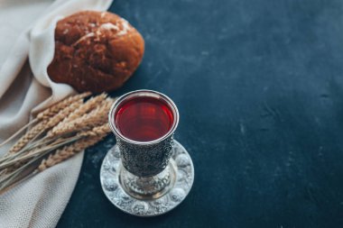 Ekmek, şarap ve buğday başakları koyu bir zemin üzerinde, komünyon kavramı.