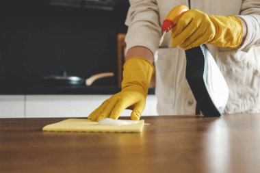 Portre sarı koruyucu lastik eldiven mutfak dolapları sünger ile temizlik kadının ellerinde.