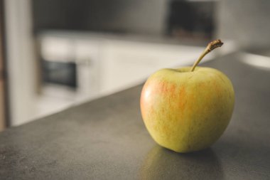 Mutfaktaki gri masada taze yeşil elma. Metin için boşluk.