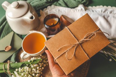 Basit bir atmosferde elinde yay olan bir hediye kutusu..