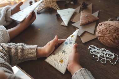 Çocuklar iplikten Noel süslemeleri yapıyorlar.