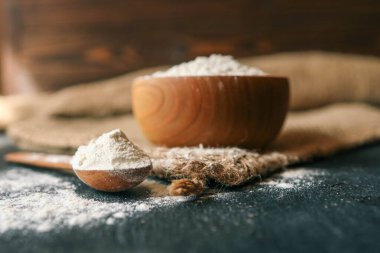 Çuval bezinde ahşap bir kasede un..