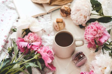 Bir fincan çay, badem kurabiyesi ve şakayık, düz bir manzara. Günaydın konsept.