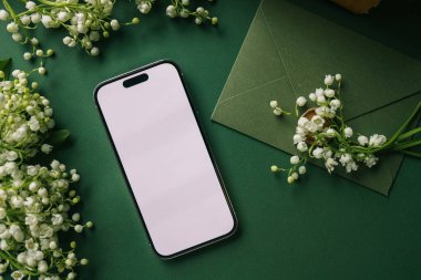 Telefon vadideki zambakların arka planında izole bir ekran ile ellerde..