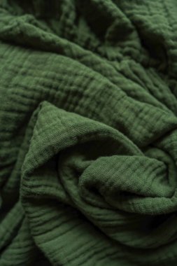 Değişik ton ve desenlere sahip yeşil desenli kumaşın detaylı bir görüntüsü, karmaşık dokuma ve malzeme kalitesini gösteriyor.