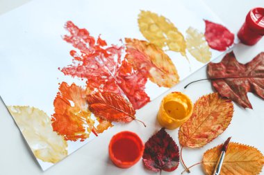 Children's autumn activity, leaf print on paper. clipart