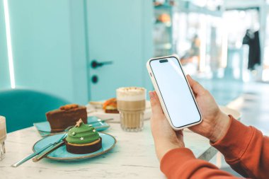 Restorandaki yemeklerin arka planında izole ekran olan telefon.