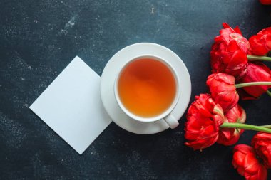 Mesajın, çayın ve bahar çiçeklerinin olduğu tebrik kartı..