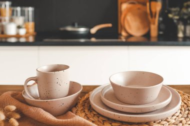Mutfağın arka planındaki masada bej rengi minimalist tabaklar..