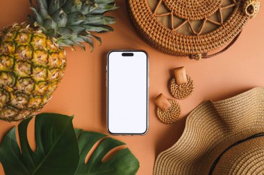 Yaz aksesuarlarının arka planında izole bir ekran olan telefon, reklam için bir yer.
