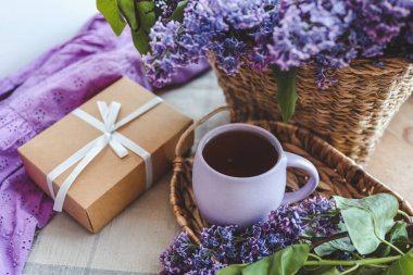 Bir fincan çay, hediye kutusu ve leylak sepeti, bahar durgun hayat..