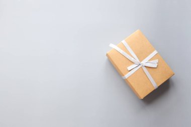 Gri arkaplanda hediye kutusu, düz üst görünüm.