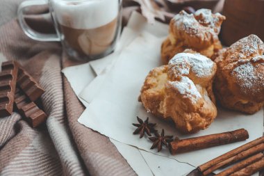 Sıcak sabah kompozisyonu, bir fincan kahve, kremalı pasta ve mum..