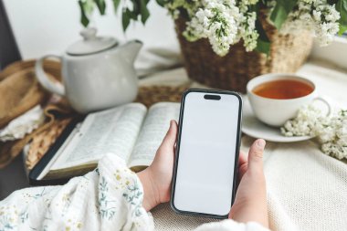 İncil 'in arka planında izole edilmiş ekranı olan ellerde telefon, metin için boşluk.