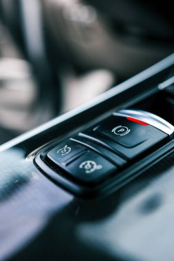 Elektronik el freni düğmesi. Vites kolu P pozisyonunda, otomatik vites arabasındaki (park) sembol. Modern otomatik vites kutusu. Araba tamiri. İçerideki araba. & Yakın çekim kullan.