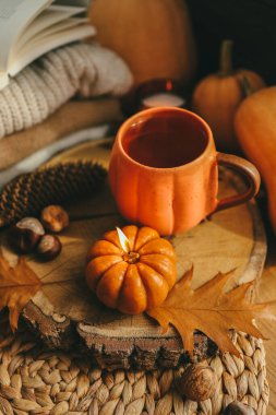 Sonbahar süsü, bir fincan çay, mumlar, balkabakları..