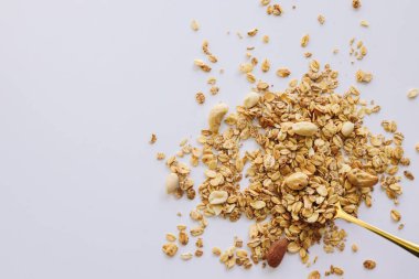 Beyaz arka planda izole kaşık üzerinde Granola, kopya alanı. Sağlıklı atıştırmalık veya kahvaltı konsepti - tahıl ve fındık ile ev yapımı granola.