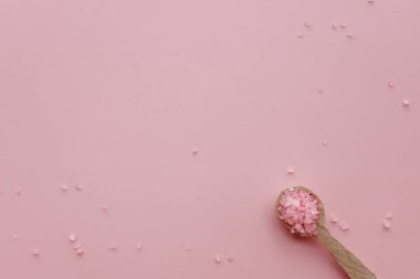 Pembe arka planda aromatik pembe Himalaya deniz tuzu. Ev yapımı bitkisel banyo tuzu. Rahatlamak için cilt bakımı güzellik banyosu kozmetik ürünleri. Doğal cilt bakımı. Üst görünüm, boşluğu kopyala. Ev spası. Aromaterapi