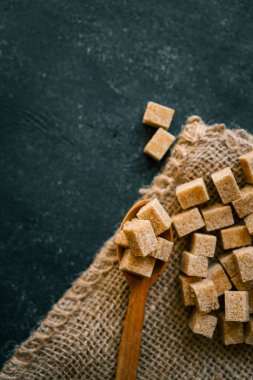 bruine suiker heap en houten lepel.