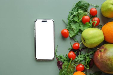 İzole ekran telefonu, taze sebzeler ve meyveler, kilo verme uygulaması.