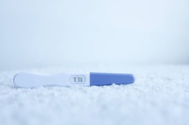 Beyaz arka planda pozitif gebelik testi.