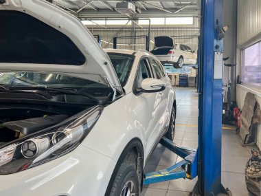 Benzin istasyonunda asansördeki beyaz araba..