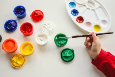 Beyaz arka planda fırça ve boya ile el.