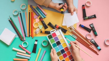 Okula dönelim. Panoramik eğitim afişi. Üst manzara, düz yatış. Masada renkli malzemeler, renkli kağıtlar. Çocukların yaratıcılık kavramı. Anaokulu eğitimi, gelişme. Okul için aksesuarlar..