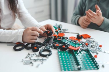 Çocuklar bir metal yapımcısıyla oynuyorlar..