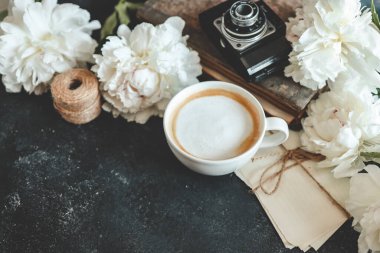 Summer composition top view. Cup of coffee, peonies and retro camera, wallpaper, space for your text.