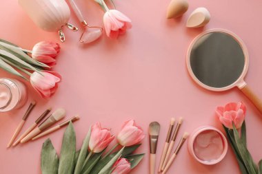 Kozmetik set üst görünüm düz pembe arkaplan üzerinde yatıyordu.