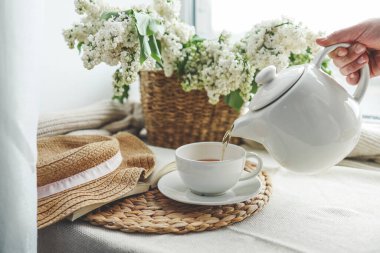 Çaydanlıktan bir fincana çay dökülüyor, güzel estetik bir fotoğraf..