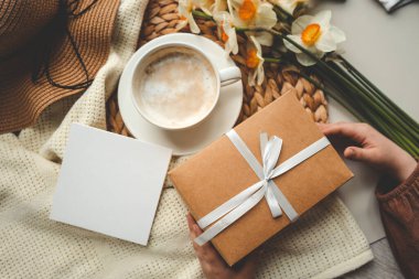 Üst manzara bahar kompozisyonu, kahve fincanı, hediye kutusu ve şapka..