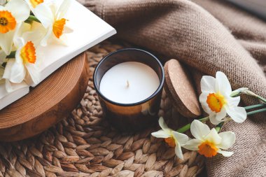 Evin içinde mum ve nergisler var..