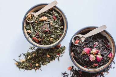 Beyaz arka planda bitki ve çiçek çayı ile tabaklar.