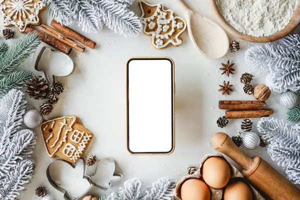Yeni yılın yemek malzemelerinin arka planında izole bir ekran olan telefon. Tarifin için yer.