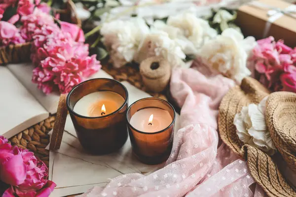 İki yanan mum ve pembe şakayık, bahar atmosferi..