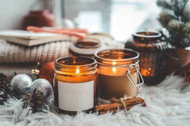 Boş etiketli bir mum, logonuz için bir yer, bir Noel iç mekanında..