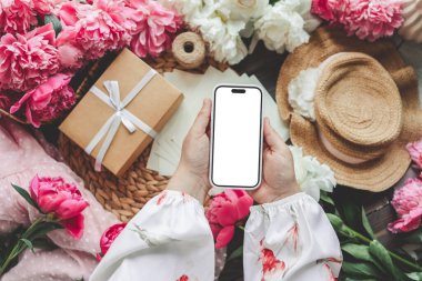 Neşeli bir arka planda cep telefonu ve bahar çiçekli şakayıklar. Aşk teması, Anneler Günü, Kadınlar Günü düzlük.