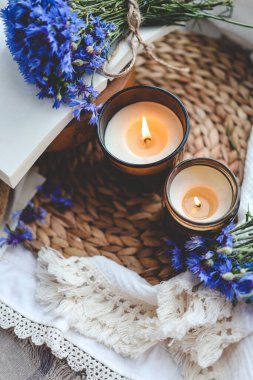 İki yanan mum, kitap ve çiçek, estetik yaz fotoğrafı..