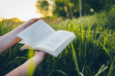 Elinde açık bir kitap, doğa konsepti, sükunet ve yalnızlık..