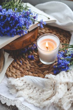 Yanan mum, kitap ve çiçek, estetik yaz fotoğrafı..