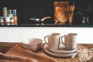 Mutfağın arka planındaki masada bej rengi minimalist tabaklar..